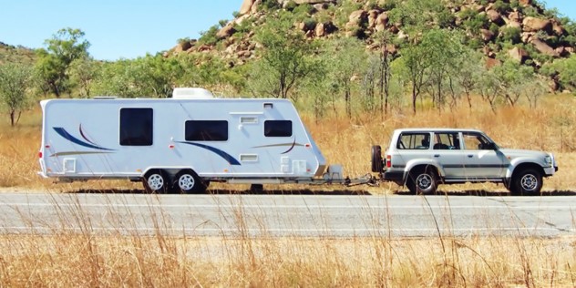 An SUV towing a caravan on a remote road