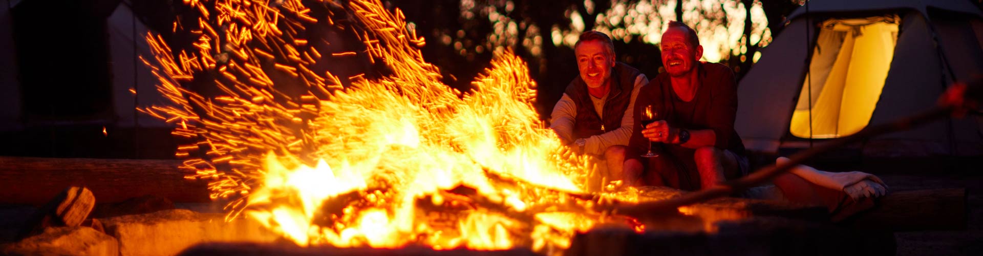 Two men camping by fire