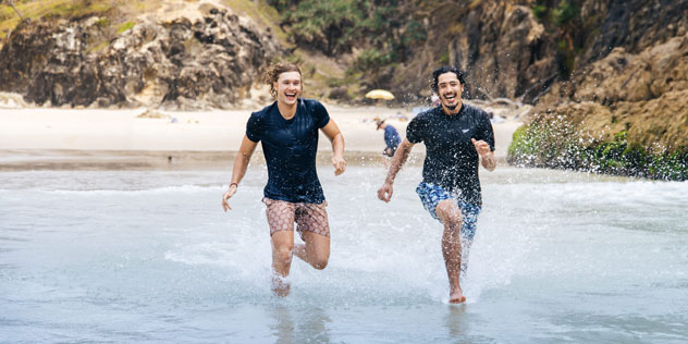 Two men running into water at South Gorge Beach