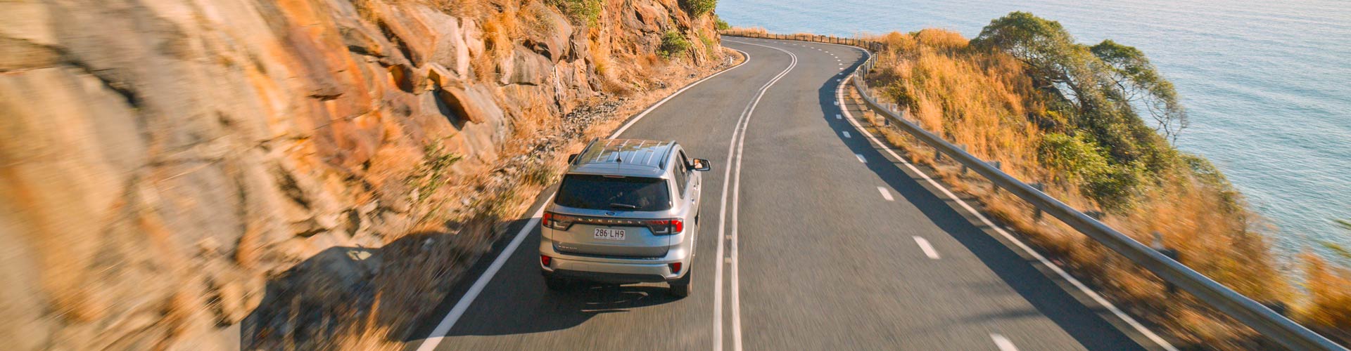 Car driving on road between Cairns and Port Douglas near Rex Lookout
