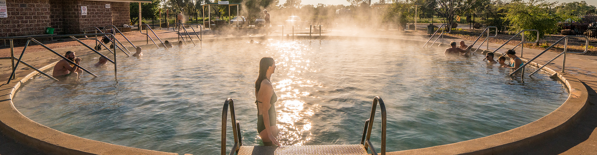 Woman enjoying a relaxing day in a naturally heated thermal pool at the Artesian Bore Baths, Lightning Ridge.