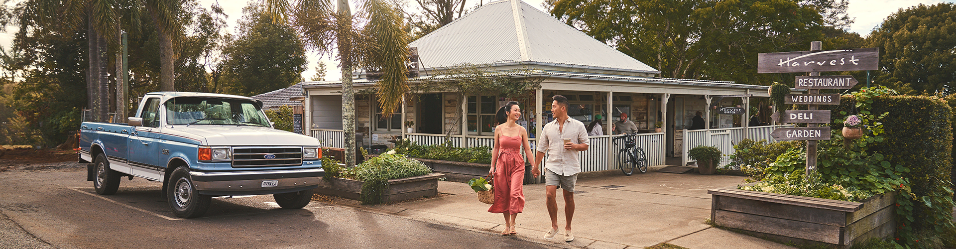 A couple walking in front of harvest at Newrybar