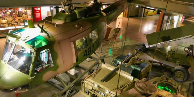  A camouflaged chopper, jeep and tank on an exhibit floor in the Australian Army Infantry Museum.