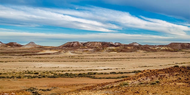 open grassy plains and distant mesas that look like lunar hills