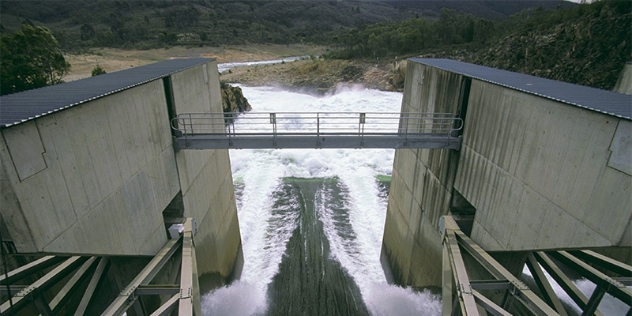 arial view of two buildings connected by a walkway across rushing water