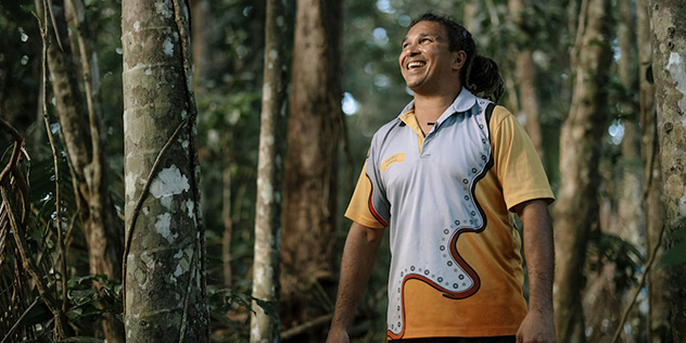 Guide Juan Walker from Walkabout Cultural Adventures gazing up at the Daintree Rainforest, Queensland © Tourism Australia