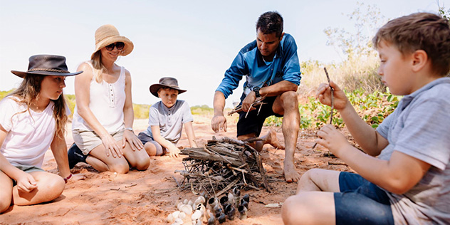 Guide Bart Pigram preparing a fire with guests in Broome, the Kimberley, Western Australia
