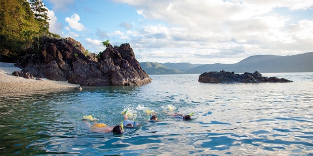 people snorkelling off a deserted beach