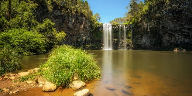 two waterfalls spill into a secluded river