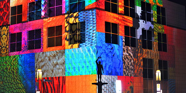 Multicoloured lights in the night sky illuminate a building