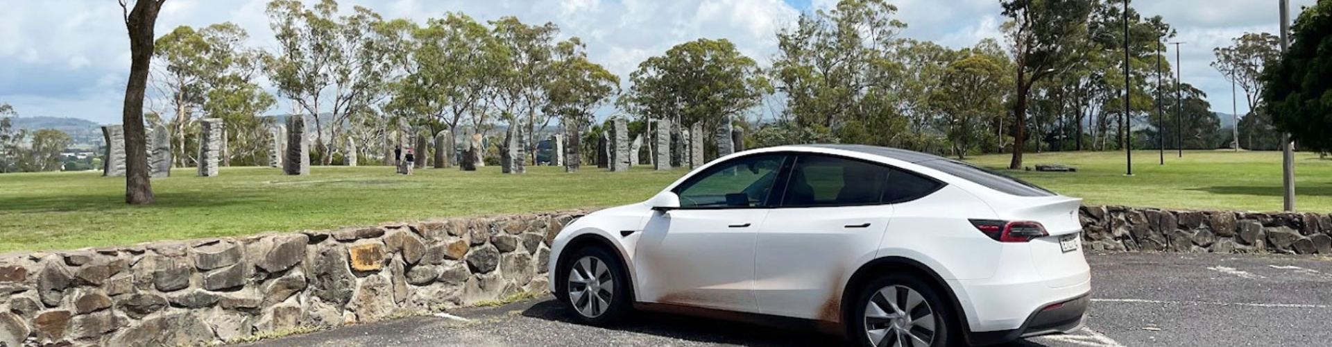 Glen Innes celtic standing stones white Tesla white tesla parked near Glen Innes celtic standing stones