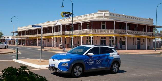 blue and white NRMA electric vehicle driving past the western model in Cobar town centre