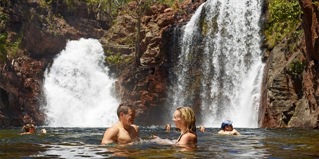 people enjoying a swim in the natural pool fed by twin waterfalls