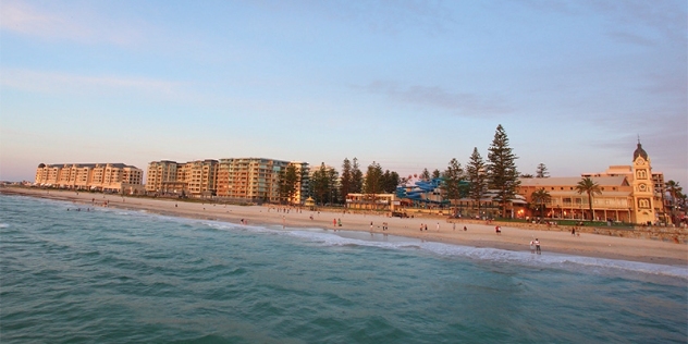 view of the beach from the ocean with a mix of heritage style buildings and holiday apartments