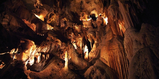 Stalactites hang down from cathedral-like cave ceiling 