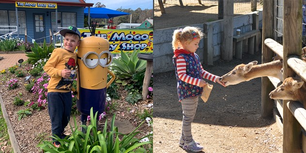 A collage of two photos, the first of a boy with his arm around a minion sculpture in a garden in front of the Mogo Lolly Shop, the other is a little girl feeding deer through a wood fence. 