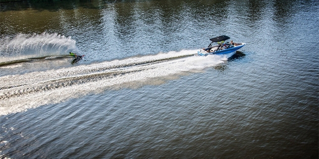 motorboat speeds through the water towing a person waterskiing 