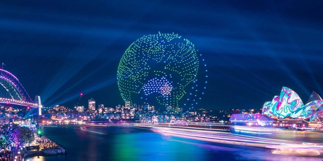  Hundreds of drones arranged to form a globe over Sydney Harbour, with the nearby Opera House also lit by colourful patterns.