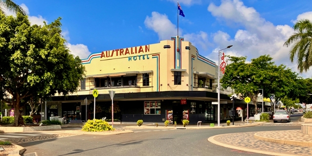 art deco style cream-coloured hotel with wide veranda sits on the corner of the street