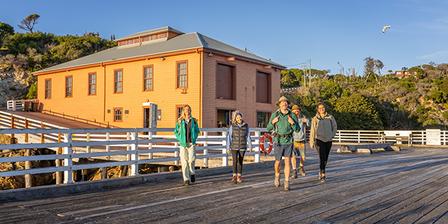 a group of people on a pier at sunset