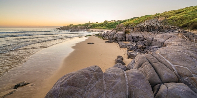 smooth rounded rocks form a semicircle on Merimbula beach