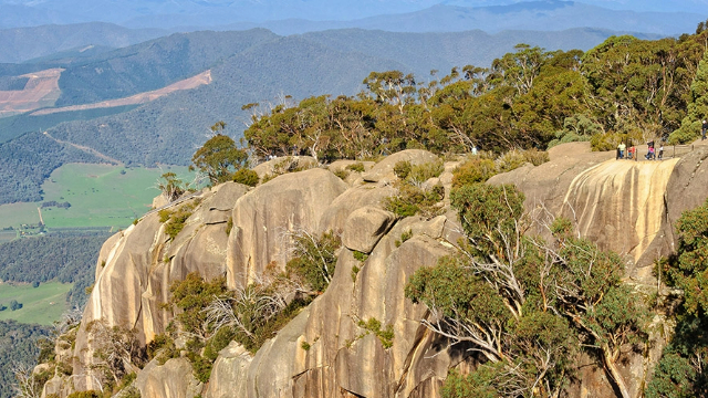 mount-buffalot-bright-vic-640x360 The top of a mountain high above green fields below, covered with rounded rocks and trees.
