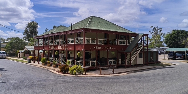 queenslander-style building with wraparound verandas and a tin roof and signage Nero Hotel on the corner of the street