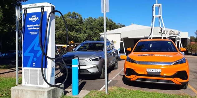 orange SIXT rental car parked at the NRMA fast charge station with Berry bowling club building in the background