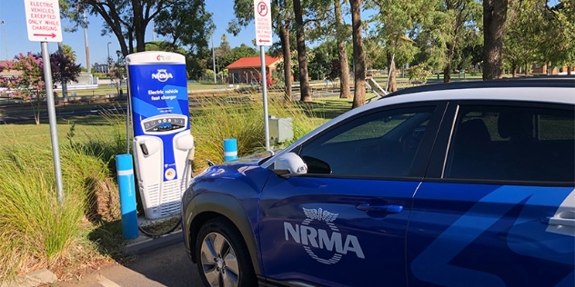 blue and white nrma electric vehicle parked in front of an nrma fast charger