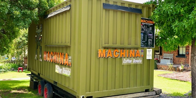 green shipping container on a trailer, converted to a mobile cafe currently closed