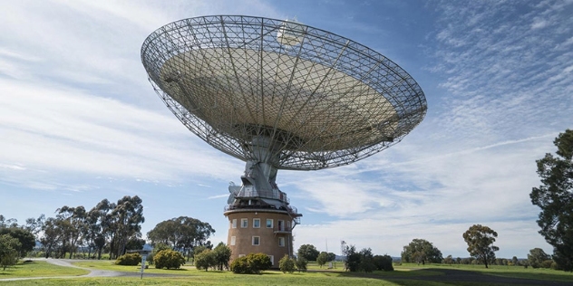 image capturing entire dish, pointing upwards, and brick base on a clear sunny day