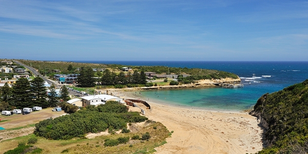 arial view of port campbell secluded beach with houses and NRMA holiday park in the background