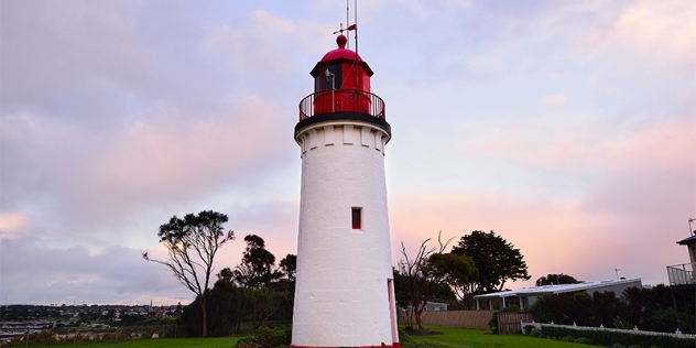 white whalers bluff lighthouse with the top painted red, viewed from the side