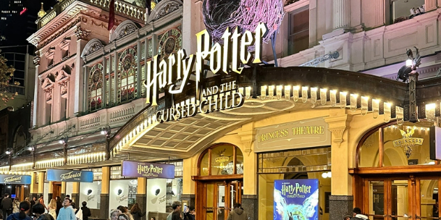 The exterior of a Broadway like theatre, with a Marquis sign for Harry Potter and the Cursed Child show.  