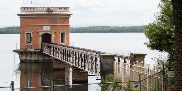  A fifteen metre bridge leading from a lakeshore to a single turret in the water, made of brick and greyed stone trim.