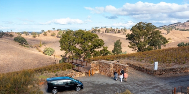 black SUV parked with people enjoying a view of undulating hills