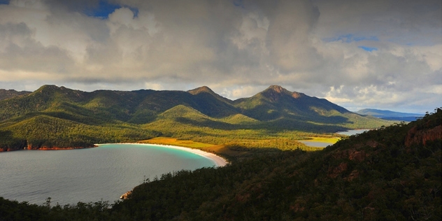 mountain top view from cradle mountain including undulating, tree covered hills and a series of lakes