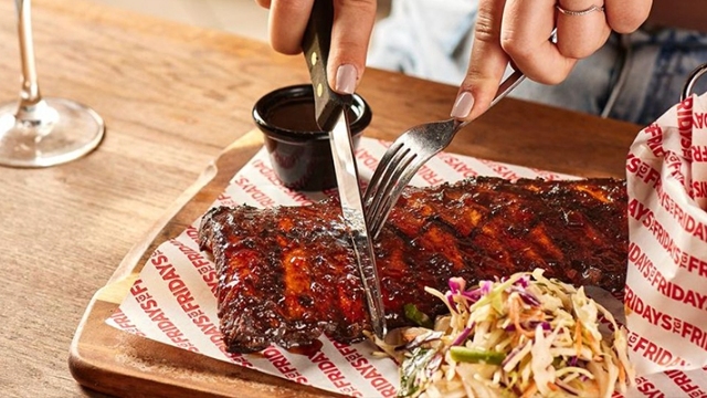 ribs, chips and coleslaw served on a wooden board