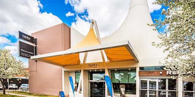 hotel entrance with large white peaked awning over the door 