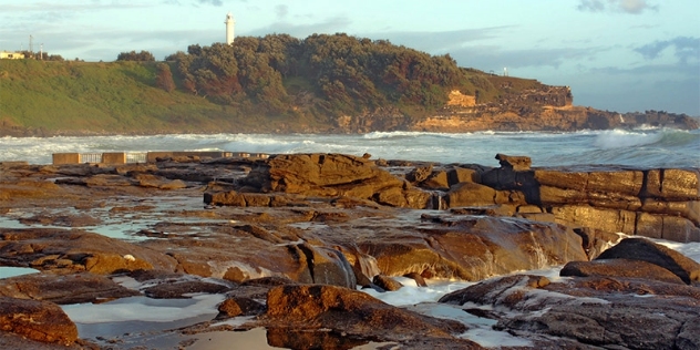 rock formations on the beach with coastline in the background